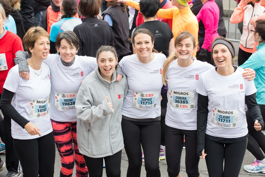 Six femmes vêtues de maillots de la Chaîne du Bonheur participent à un événement sportif et collectent des dons grâce à la solidarité active et à la visibilité.