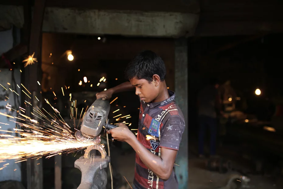 Jeune exposé au travail dangereux – besoin d’aide au développement Un jeune travaille avec des outils dangereux au Bangladesh - L'aide au développement est nécessaire car le travail des enfants est très répandu.