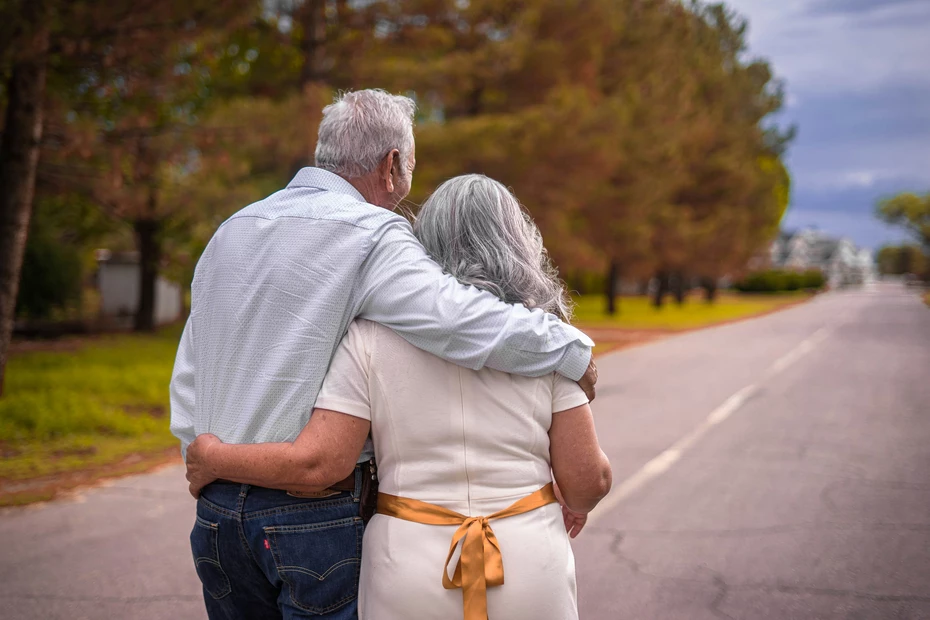 Héritage et legs - Unis dans la solidarité Couple âgé marchant bras dessus bras dessous sur une route tranquille - laissez un impact durable grâce aux dons par héritage et aux donations testamentaires.
