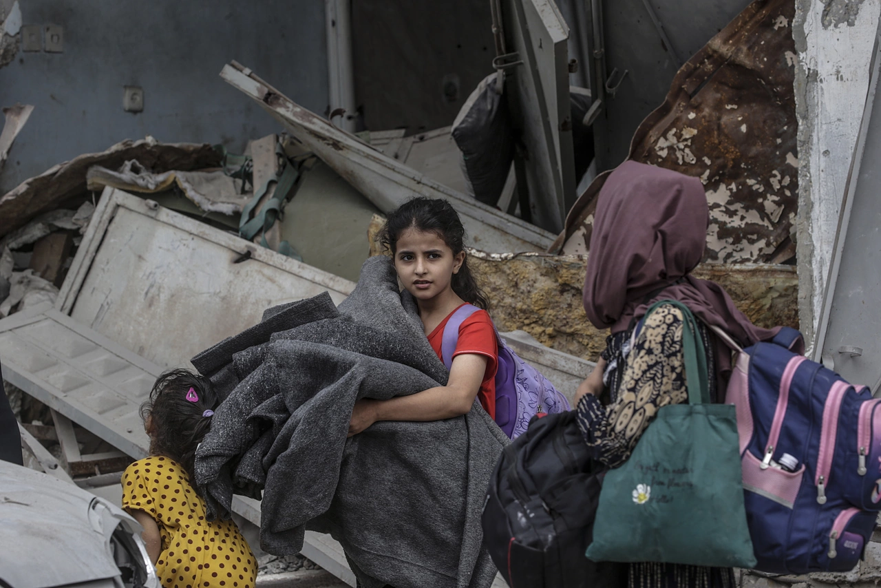 Une jeune fille à Gaza avec ses affaires – contrainte de fuir, elle a besoin d’une aide urgente.