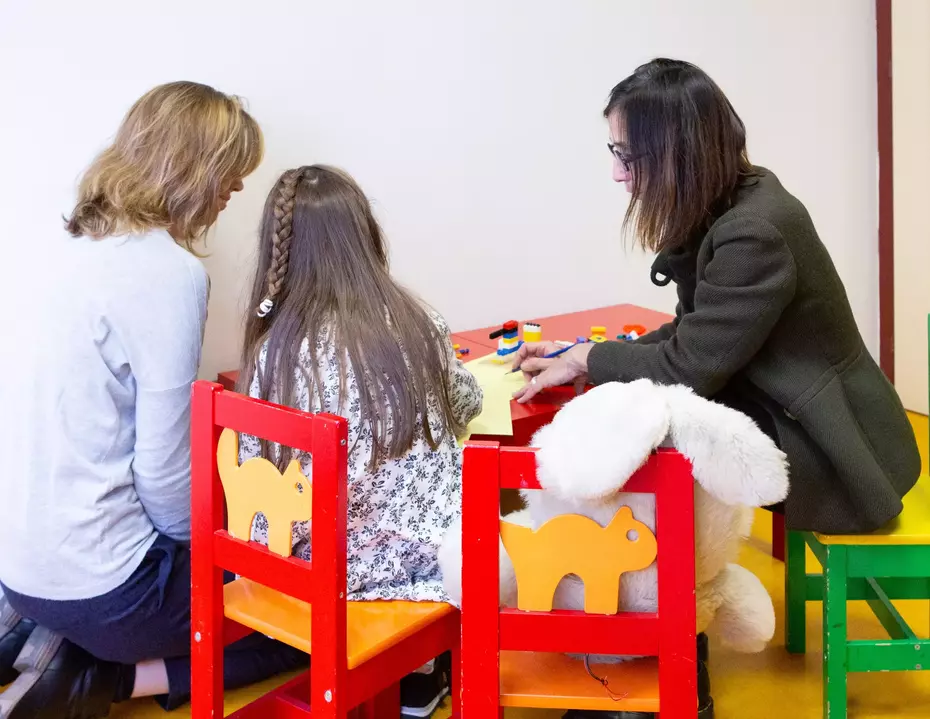 Offrir sécurité et repères aux enfants Deux femmes accompagnent un enfant dans un espace protégé – un soutien essentiel pour les enfants vulnérables, alliant protection, aide durable et écoute.