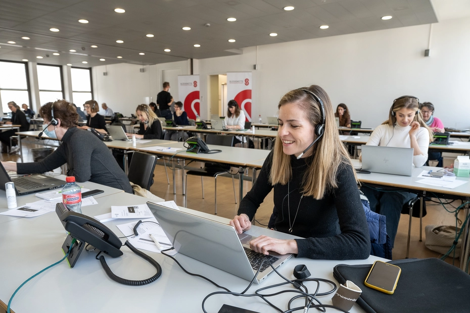 Une femme reçoit des dons au téléphone - grâce à la journée nationale de solidarité, une aide urgente peut être apportée.