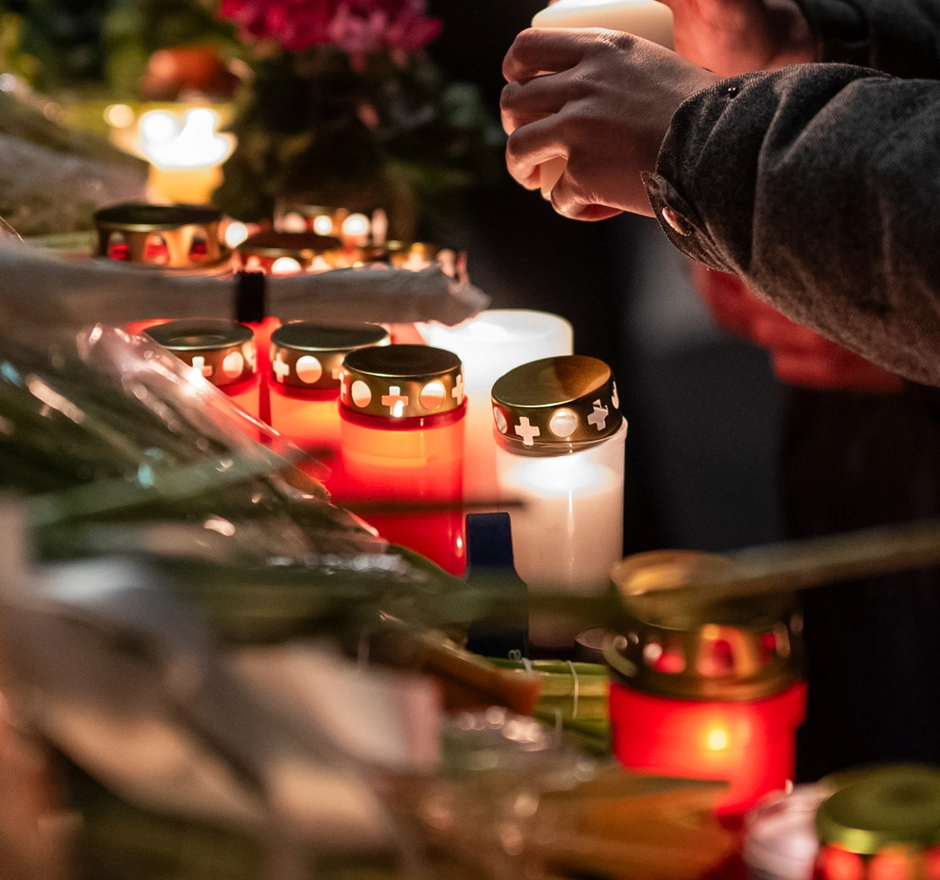 Une personne allume des bougies pour un autel de deuil.