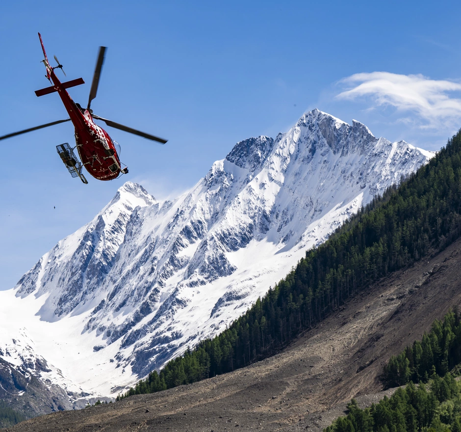 Hélicoptère de sauvetage en mission au-dessus de la zone de glissement de terrain de Blatten - don urgent pour une aide d'urgence rapide.