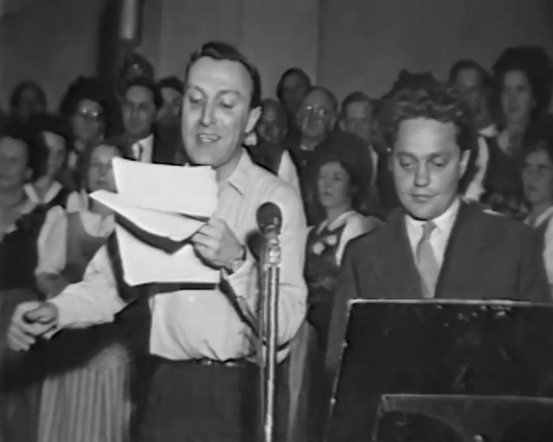 Deux hommes parlent dans un micro lors d'une première campagne de collecte de fonds - la création de la Chaîne du Bonheur.