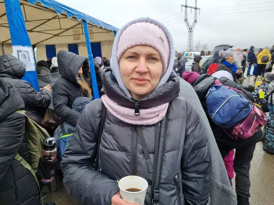 Aide d’urgence pour les réfugiés en Ukraine Une femme en manteau d’hiver tient un gobelet de boisson chaude dans un centre d’aide aux réfugiés en Ukraine – un geste d’espoir et de soutien au cœur de la guerre en Ukraine.