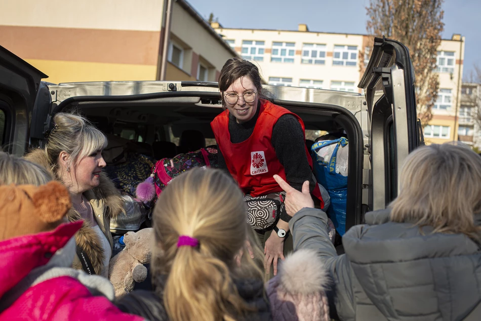 Aide en espèces dans l’oblast d’Odessa Une employée de Caritas échange avec des femmes et enfants réfugiés près d’un véhicule – distribution d’une aide en espèces dans l’oblast d’Odessa, en Ukraine.
