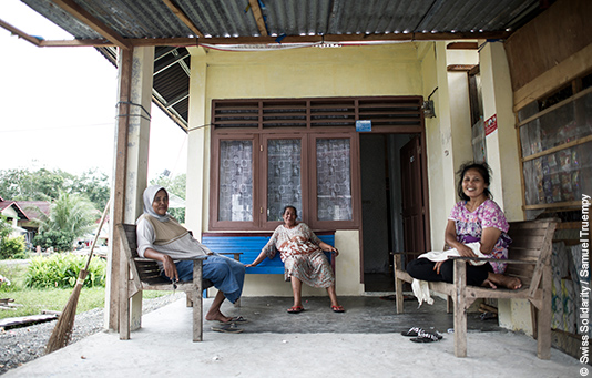 une famille devant sa nouvelle maison reconstruite après le tsunami.
