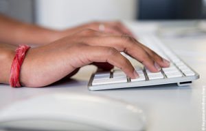 Online donation – a person types at a computer keyboard.