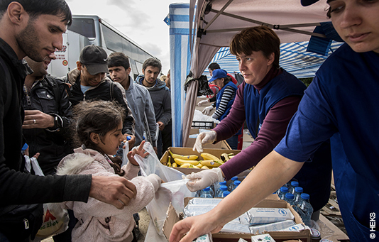 Des réfugiés en Serbie reçoivent de quoi manger lors d'une distribution de nourriture de notre ONG partenaire EPER.